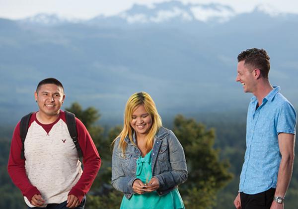 Three Indigeous young people laughing together.
